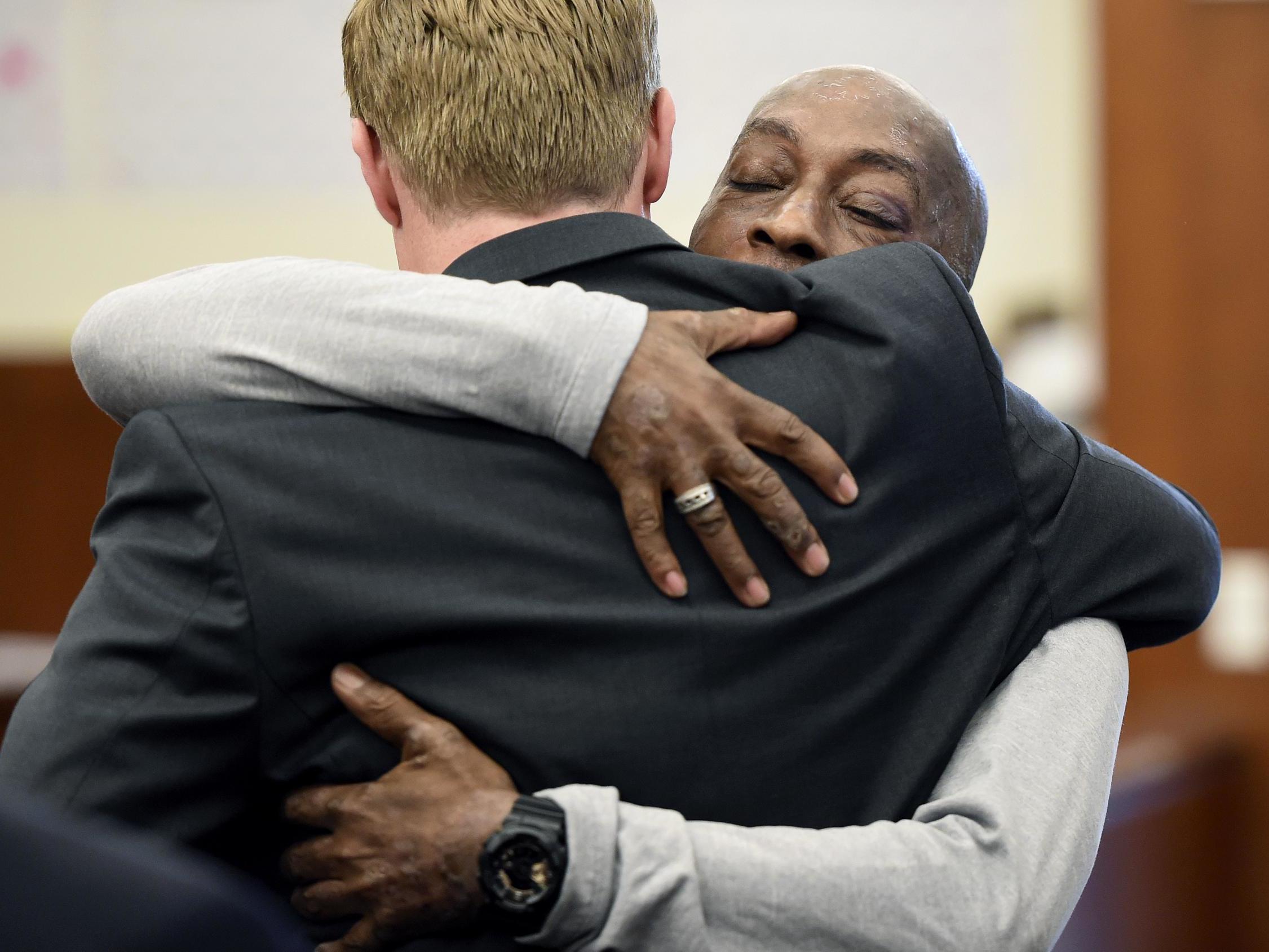 Dewayne Johnson hugs one of his lawyers after Monsanto was ordered to pay him $289m in damages