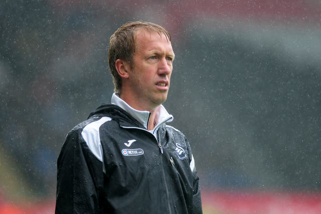 Graham Potter withstands the rain as he watches Swansea's victory over Preston North End