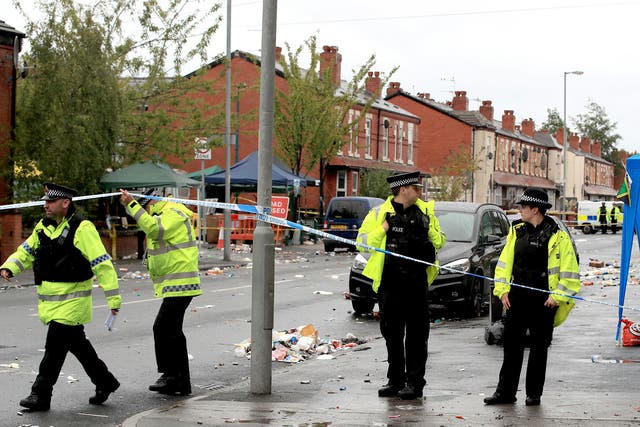 Police officers at the scene in Claremont Road, Moss Side, Manchester, where several people have been injured after a shooting