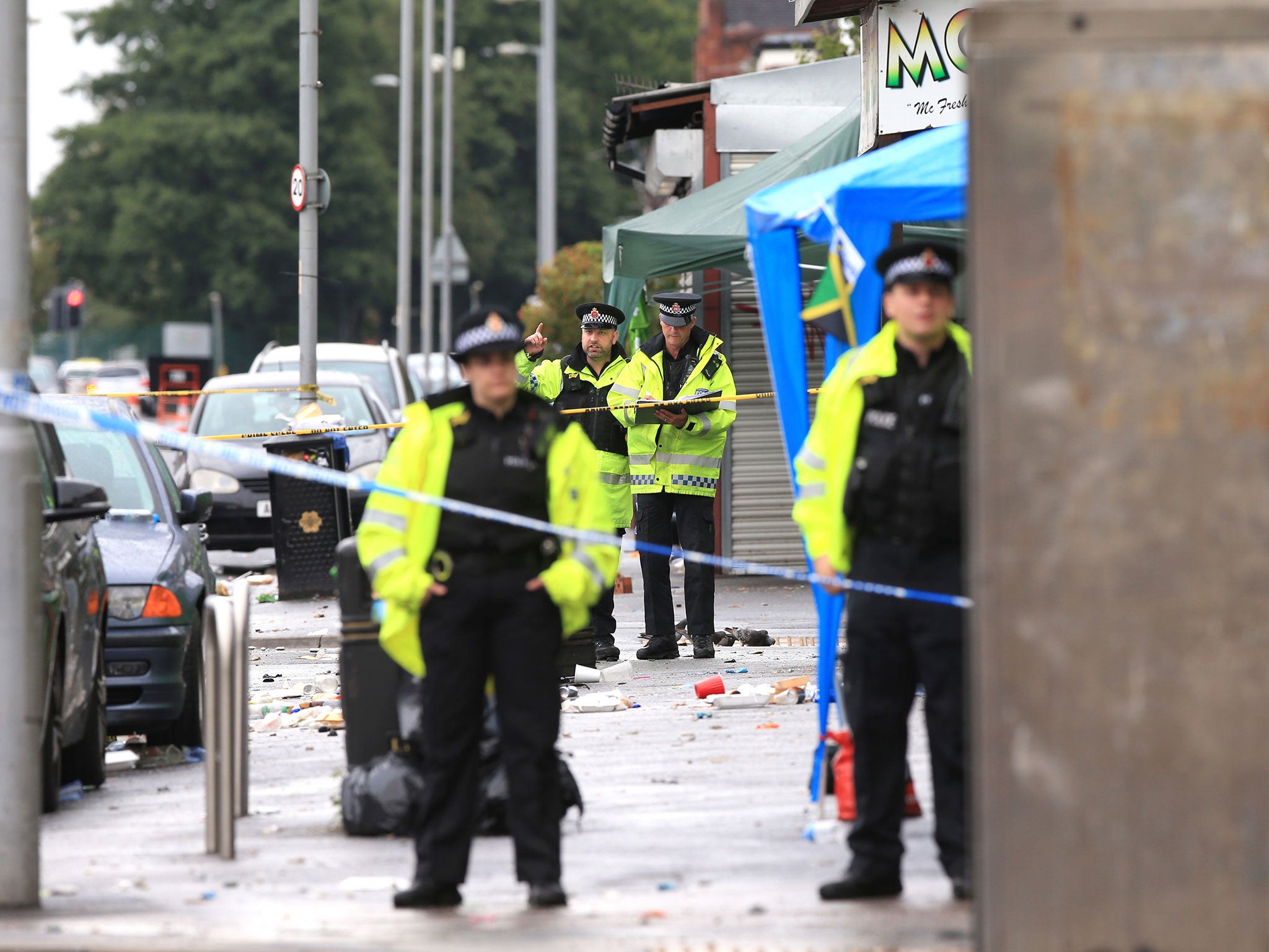 Police officers at the scene in Claremont Road, Moss Side, Manchester, where several people have been injured after a shooting (Peter Byrne/PA Wire)