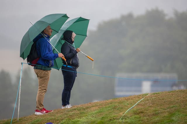 Golf shelter from the rain as they watch the European Championships at Gleneagles on Sunday
