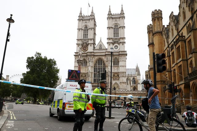 Police officers stand at a cordon after a car crashed outside the Houses of Parliament in Westminster