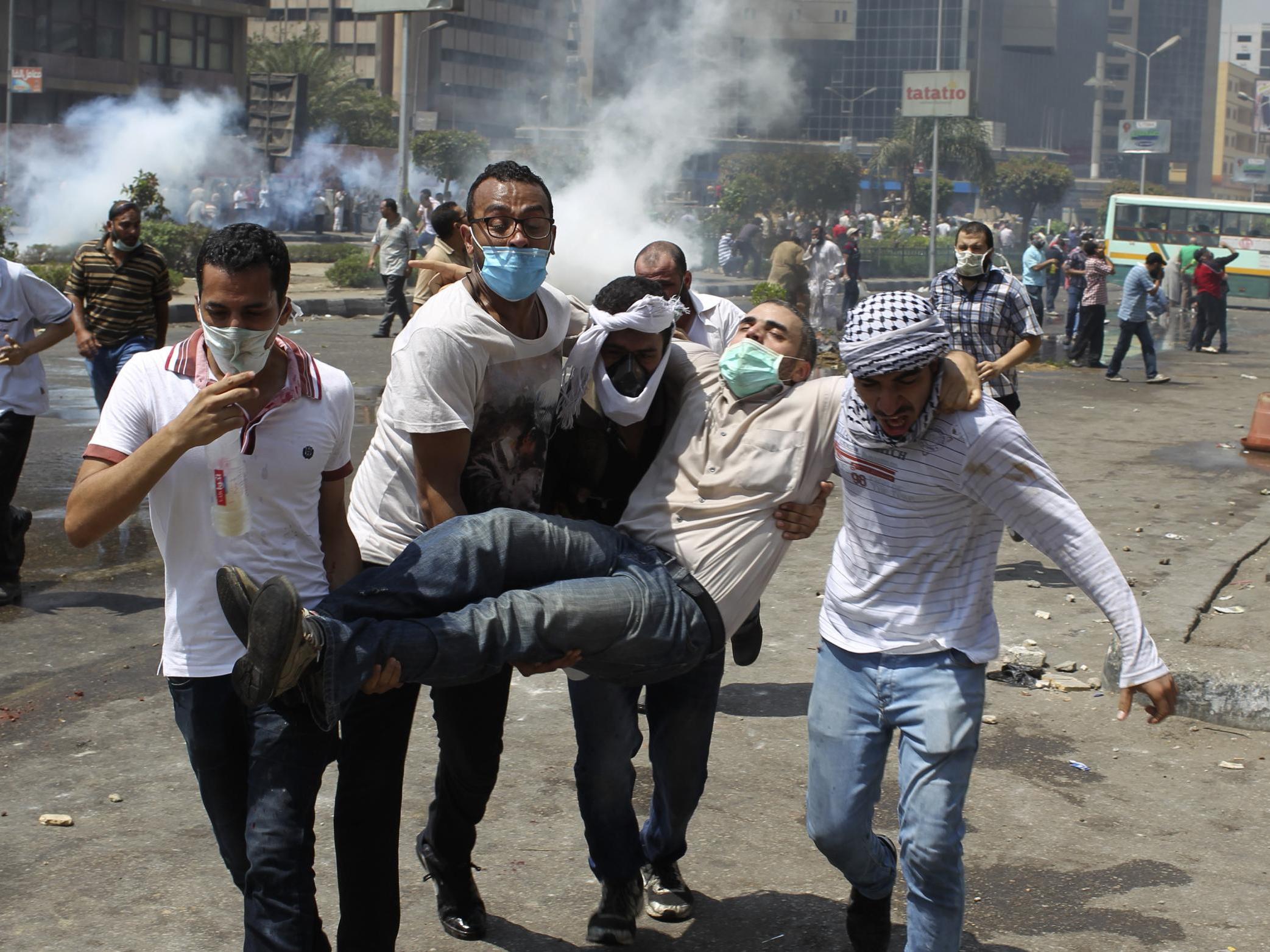 Supporters of deposed Egyptian president Morsi carry an injured protester from Cairo’s Rabaa square