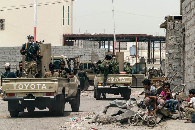 Yemeni fighters loyal to the Saudi and UAE-backed government patrolling a street in Aden