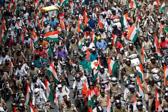 People hold tricolour flags at a rally on the eve of India's 72nd Independence Day in Ahmedabad, India