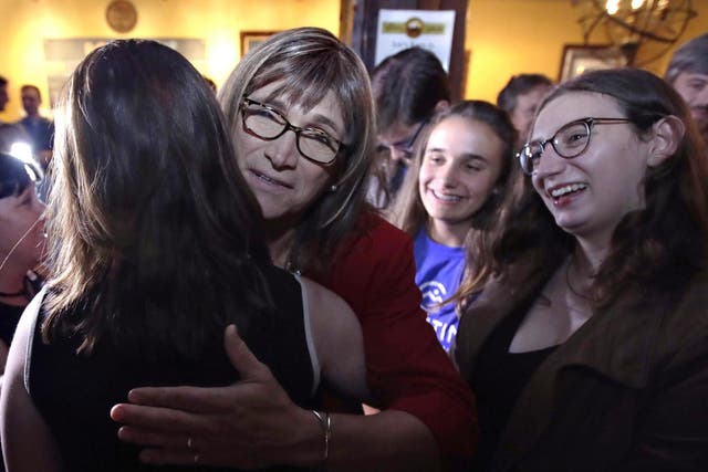 Vermont Democratic gubernatorial candidate Christine Hallquist, centre, a transgender woman and former electric company executive, embraces supporters after claiming victory during her election night party in Burlington, Vermont