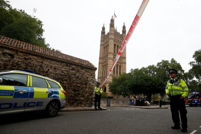 Police officers stand at a cordon after a car crashed outside the Houses of Parliament in Westminster