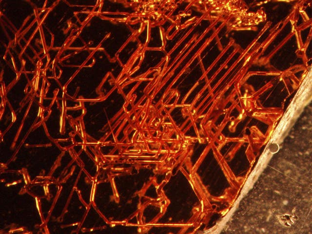 Microscopic tubular structures found within a red garnet crystal - the deep red gems have long been found marred with internal markings
