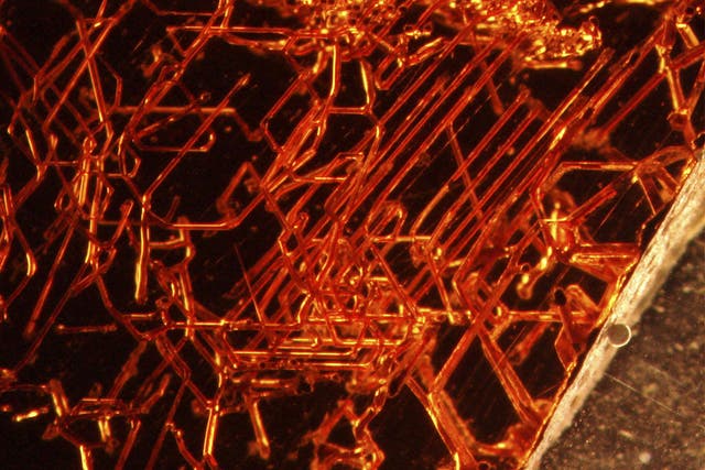 Microscopic tubular structures found within a red garnet crystal - the deep red gems have long been found marred with internal markings
