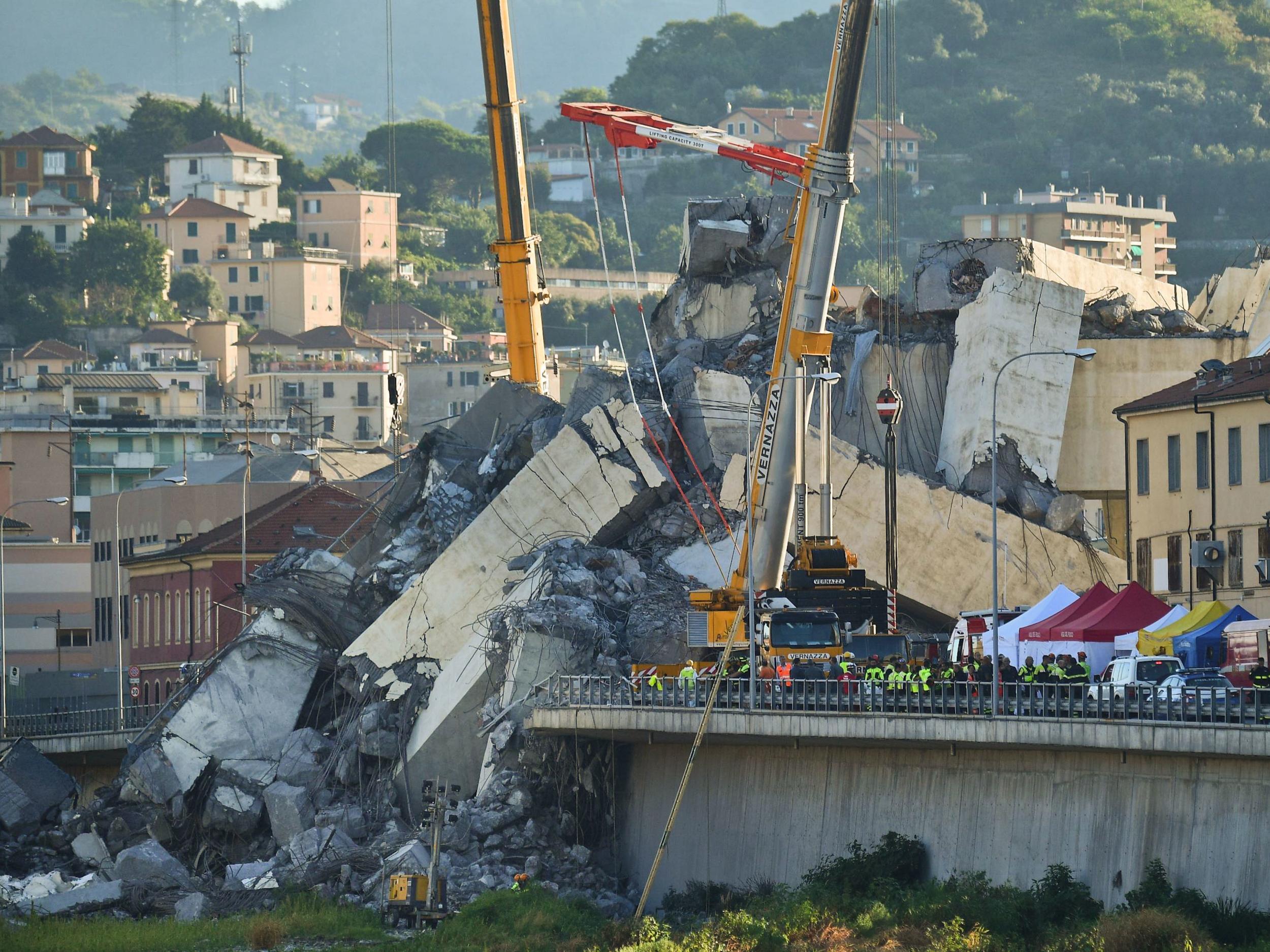 Rescuers search the crumbled hulk of the collapsed Morandi highway bridge in Genoa, northern Italy, on Wednesday