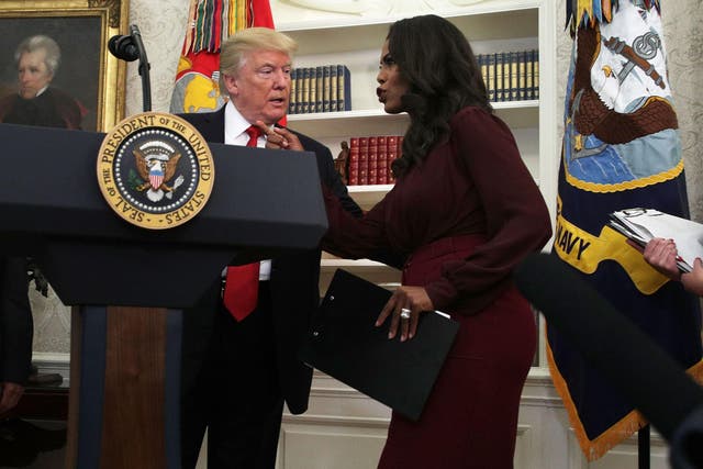 U.S. President Donald Trump listens to Director of Communications for the White House Public Liaison Office Omarosa Manigault during an event in the Oval Office of the White House October 24, 2017 in Washington, DC