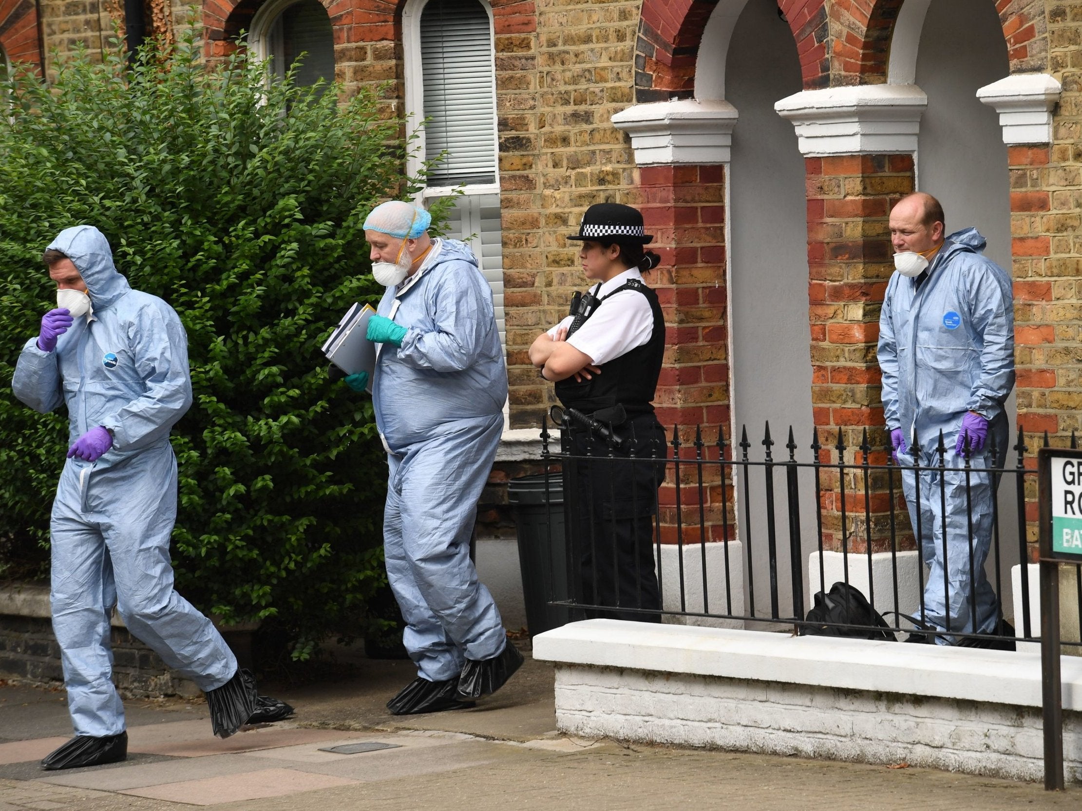 Forensic workers and a police officer outside a home in Grayshott Road in Battersea, south-west London
