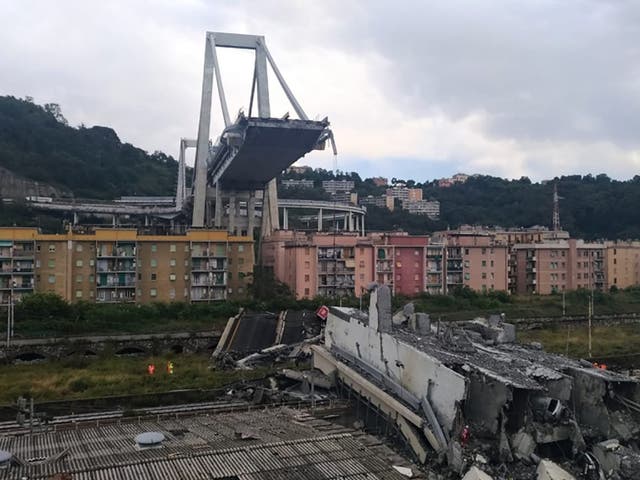 Rescuers work amid rubble and wreckage after the collapse of a section of the Morandi Bridge in Genoa