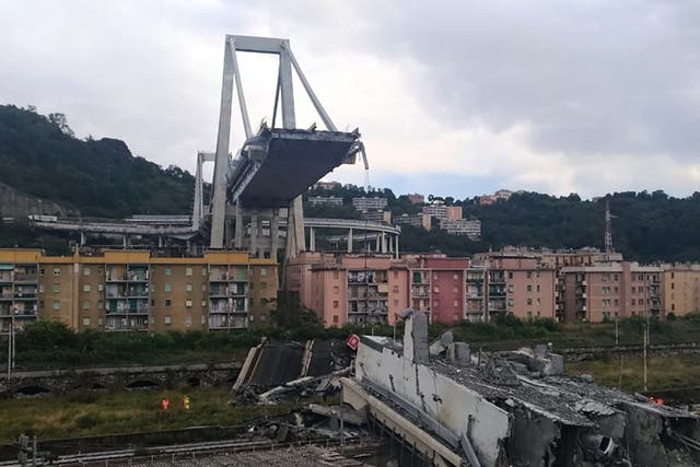 Rescuers work amid rubble and wreckage after the collapse of a section of the Morandi Bridge in Genoa