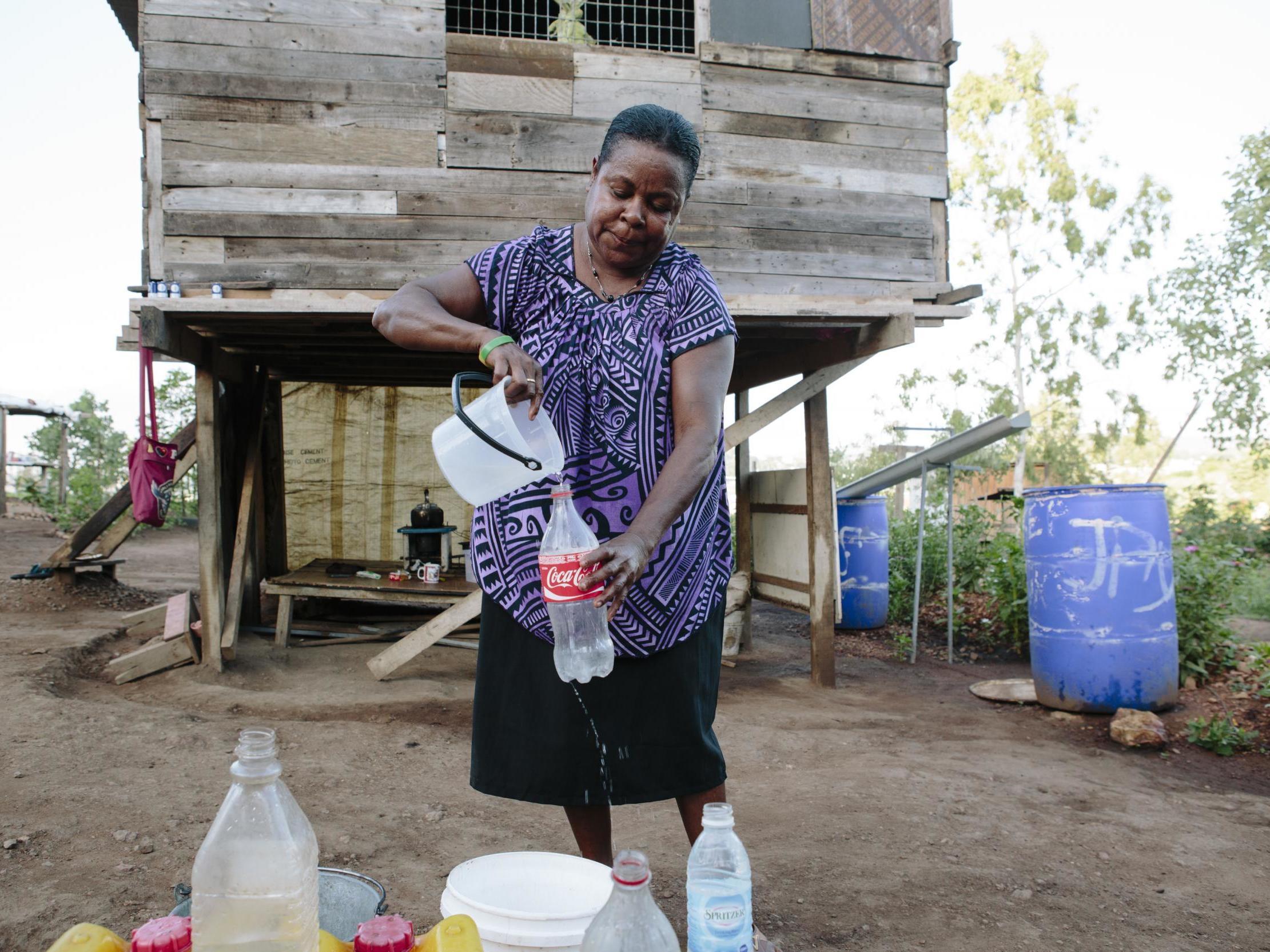 A woman washes up using a communal tap in her village in Papua New Guinea