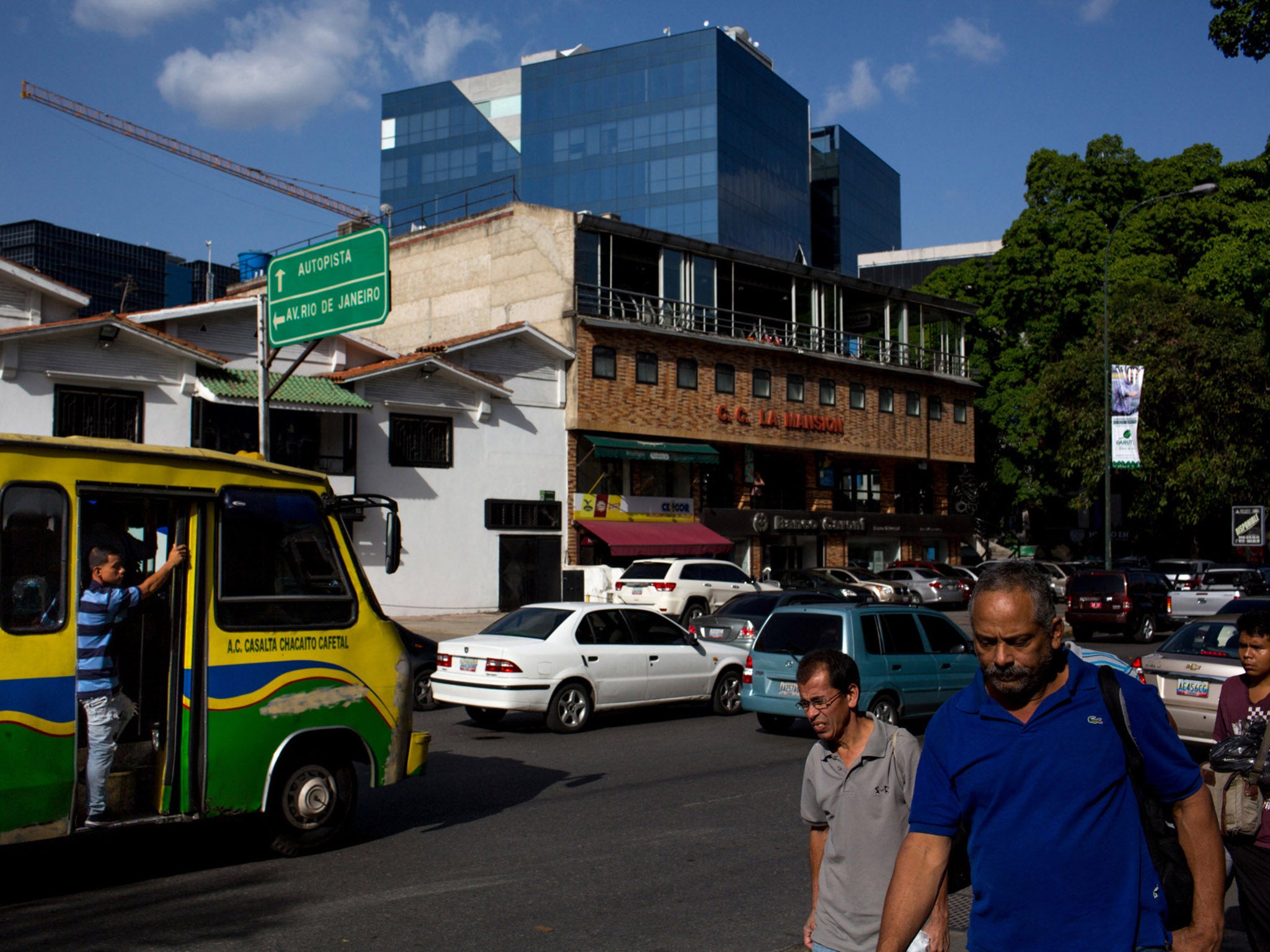 Cranes and new glass offices rise above the main avenue of Las Mercedes in Caracas