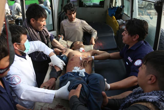 A man who was injured in suicide bombing that targeted a training class in a private building in the Shiite neighborhood of Dasht-i Barcha is placed in an ambulance, 15 August 2018