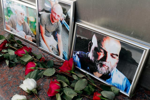 Flowers are placed as a last tribute in front of the photographs of Russian journalists Alexander Rastorguyev (L), Kirill Radchenko (C) and Orkhan Dzhemal (R) outside the Central House of Journalists in Moscow, Russia