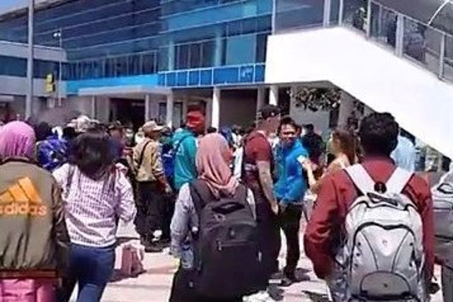 People evacuate from Lombok International Airport after a 6.3-magnitude earthquake struck the island