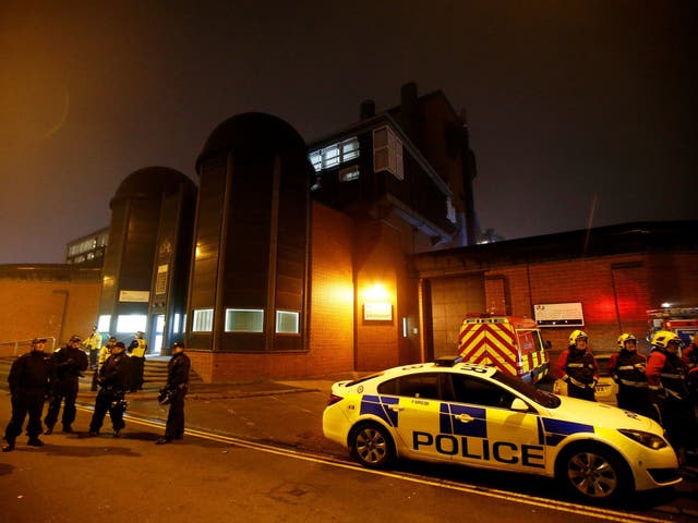 Police officers and firemen stand outside Winson Green prison, run by security firm G4S, after a serious disturbance broke out on 16 December 2016