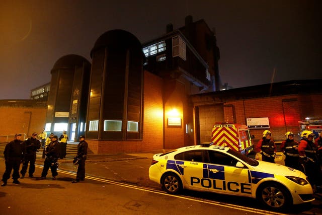 Police officers and firemen stand outside Winson Green prison, run by security firm G4S, after a serious disturbance broke out on 16 December 2016