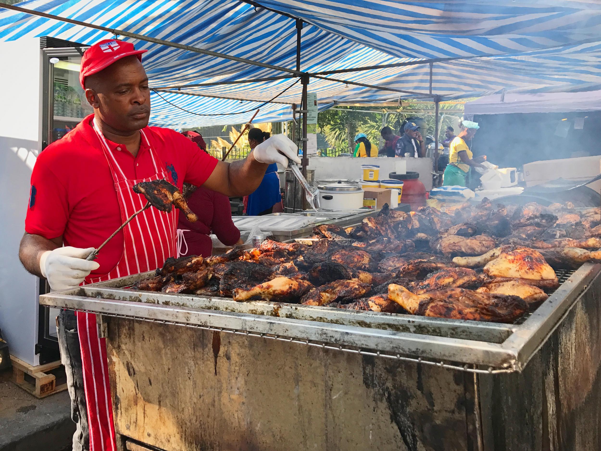 A cook prepares the carnival favourite jerk chicken on the BBQ at Notting Hill Carnival