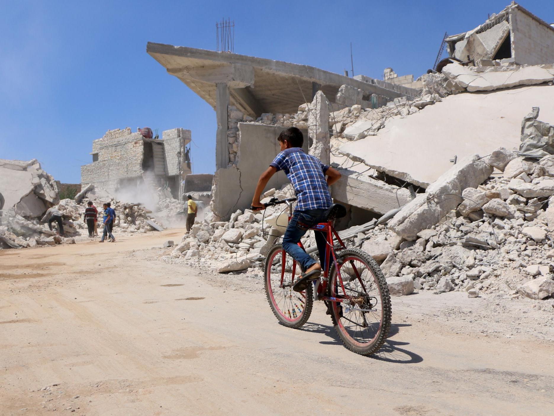A boy rides his bicycle in the Syrian ebel-held town of Orum al-Kubra in northern Aleppo province near Idlib on 11 August 2018