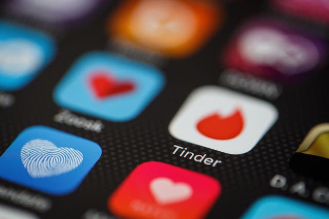 The 'Tinder' app logo is seen amongst other dating apps on a mobile phone screen