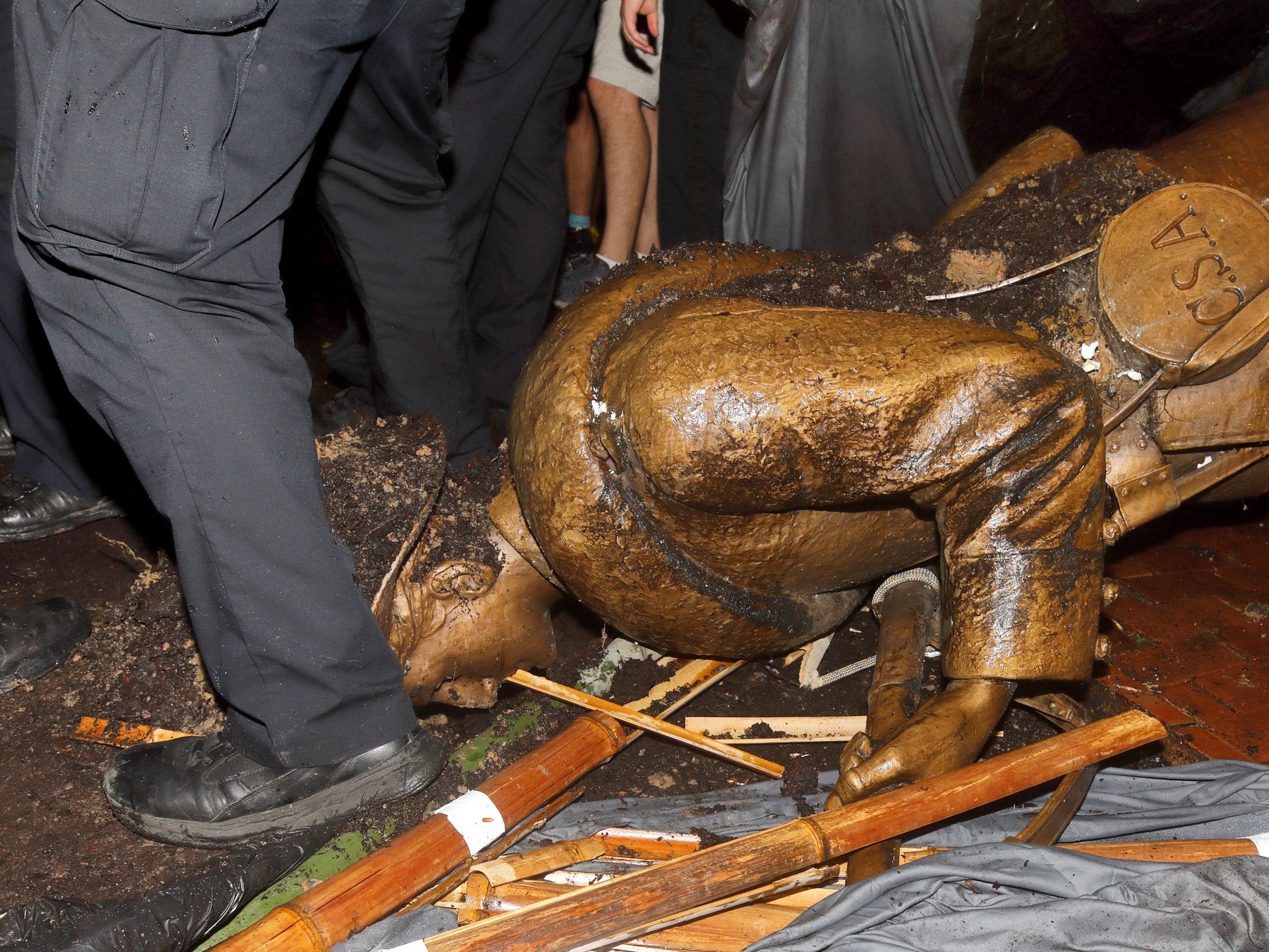 Police surround the toppled statue of the Confederate soldier known as Silent Sam
