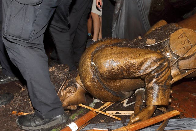 Police surround the toppled statue of the Confederate soldier known as Silent Sam