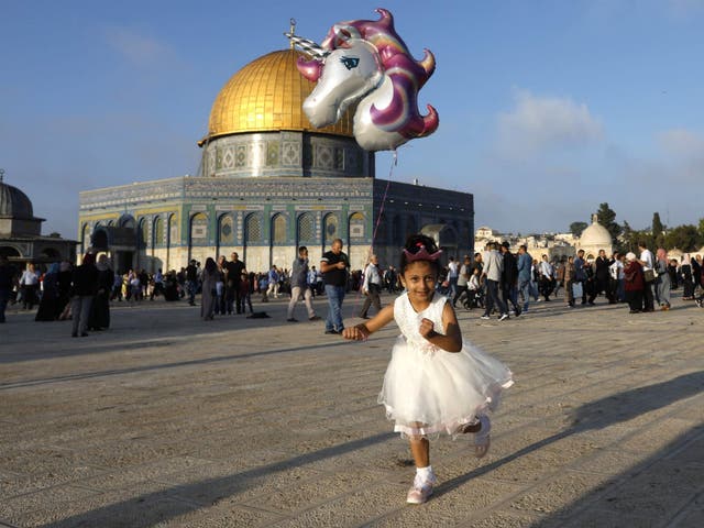 A young Palestinian girl flies a balloon near the Dome of the Rock at al-Aqsa Mosque compound in Jerusalem's old city on the first day of Eid al-Adha