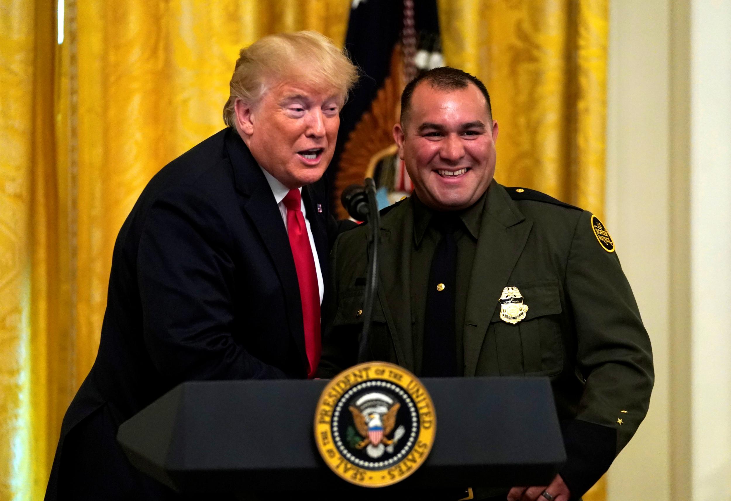 US President Donald Trump brings up Border Patrol agent Adrian Anzaldua to speak during a Salute to the Heroes event at the White House in Washington, U.S., August 20, 2018
