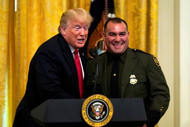US President Donald Trump brings up Border Patrol agent Adrian Anzaldua to speak during a Salute to the Heroes event at the White House in Washington, U.S., August 20, 2018