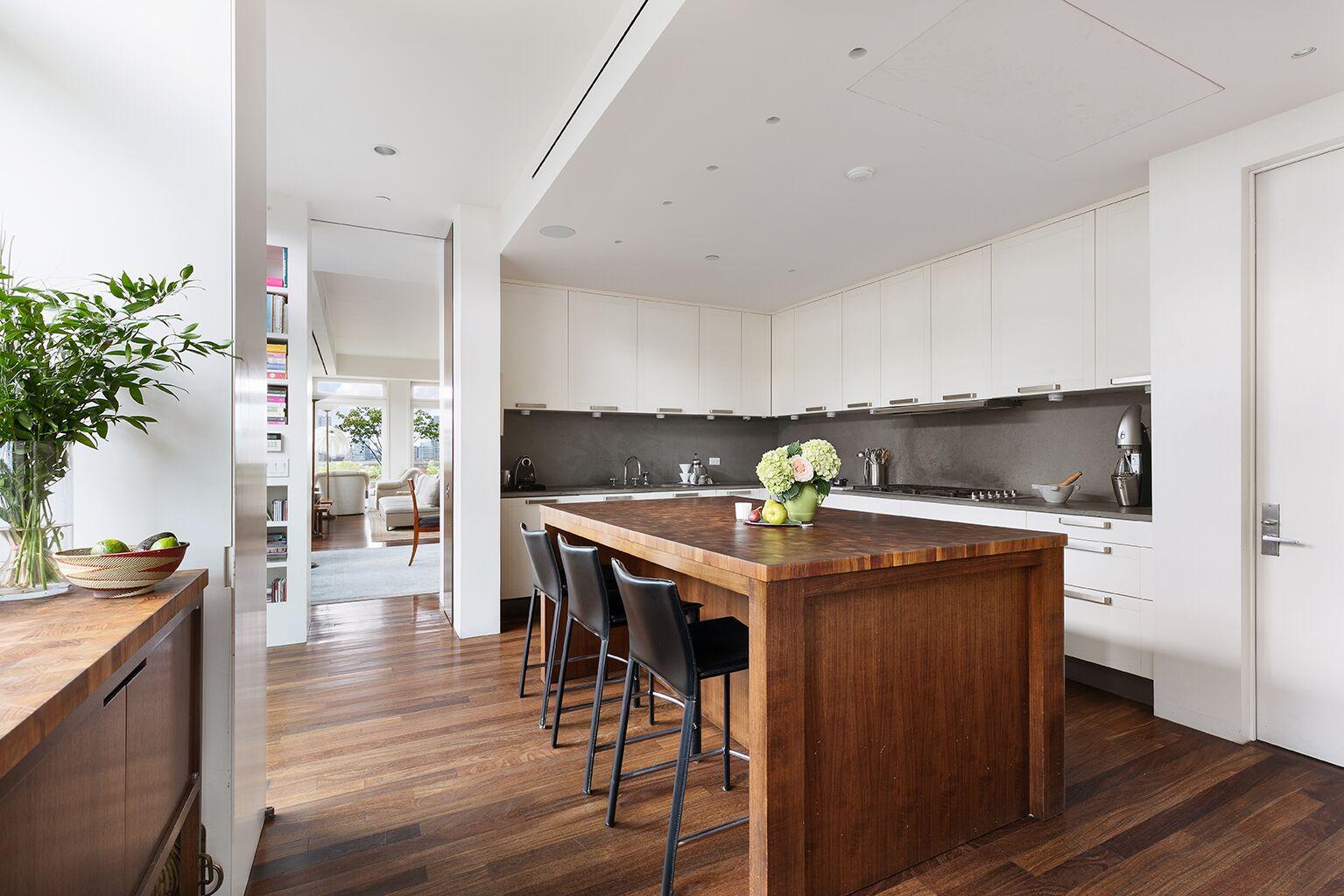 The elegant kitchen that features two Miele ovens and 6 burner cooktop with a dark butcher block island