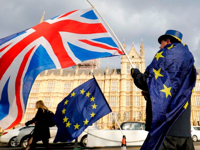 An anti-Brexit demonstrator waves a Union flag alongside a European Union flag outside the Houses of Parliament