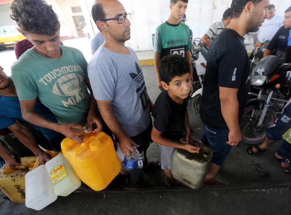 Palestinians in Gaza wait to fill containers after Israel stopped the transfer of fuel and cooking gas into the enclave in July