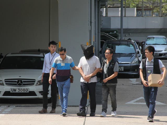 File photo shows Malaysian national Khaw Kim-sun (C), being arrested on suspicion of murdering his wife and daughter