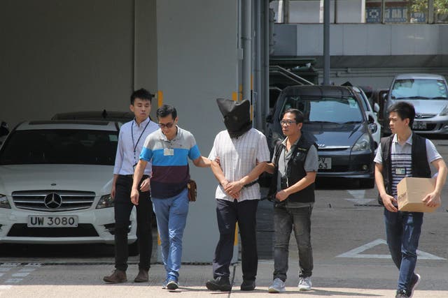 File photo shows Malaysian national Khaw Kim-sun (C), being arrested on suspicion of murdering his wife and daughter