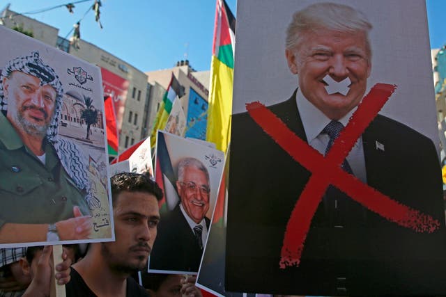Palestinian protestors hold portraits of late Palestinian leader Yasser Arafat and US President Donald Trump earlier this month.
