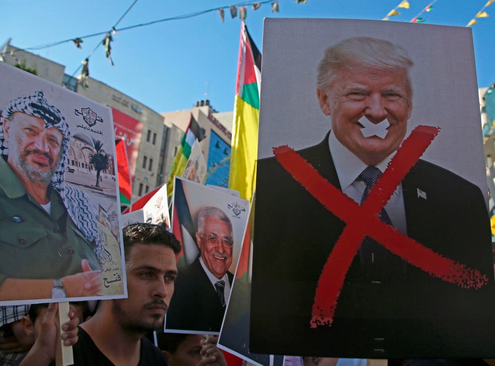 Palestinian protestors hold portraits of late Palestinian leader Yasser Arafat and US President Donald Trump earlier this month.
