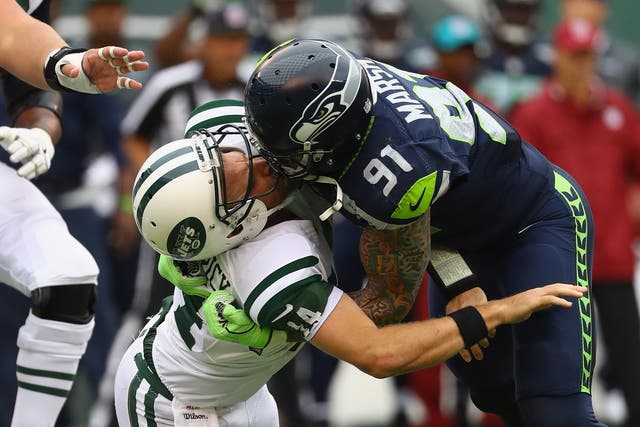 EAST RUTHERFORD, NJ - OCTOBER 02: Cassius Marsh #91 of the Seattle Seahawks hits his helmet against quarterback Ryan Fitzpatrick #14 of the New York Jets for a penalty 'Roughing the Passer' in the second quarter at MetLife Stadium on October 2, 2016 in East Rutherford, New Jersey.