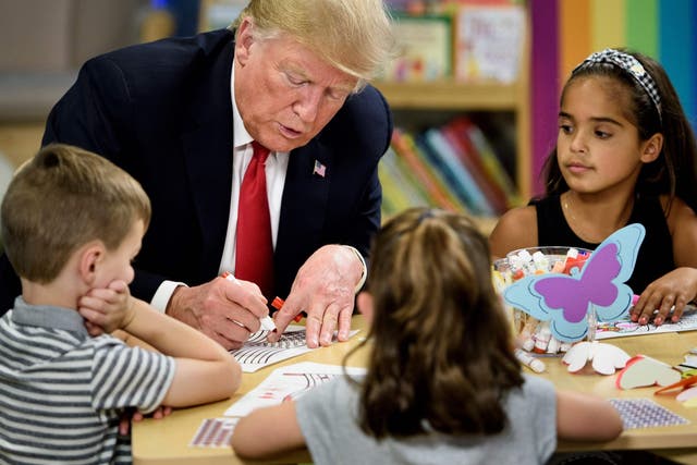 Donald Trump begins his attempt to colour in an American flag during a tour of the Nationwide Children's Hospital in Columbus, Ohio