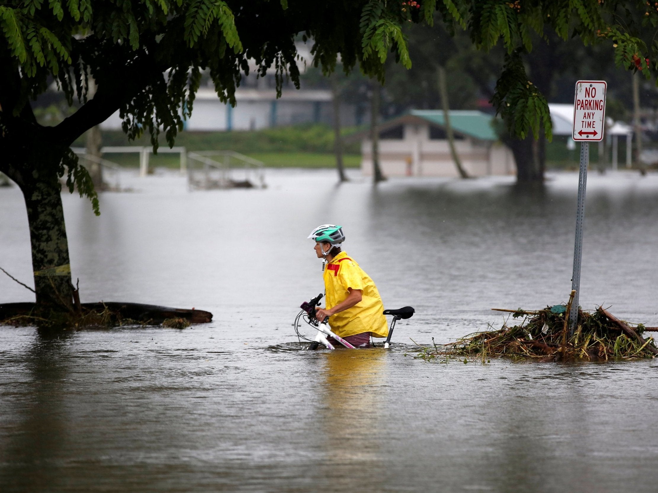 A woman pushes her bike through flooding caused by tropical storm Lane in Hilo, on Hawaii's Big Island