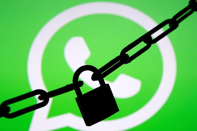 A photo illustration shows a chain and a padlock in front of a displayed Whatsapp logo