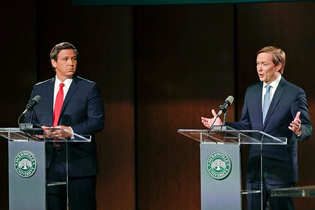 Republican gubernatorial candidate Ron DeSantis, left, listens to opponent Adam Putnam during a debate in Jacksonville