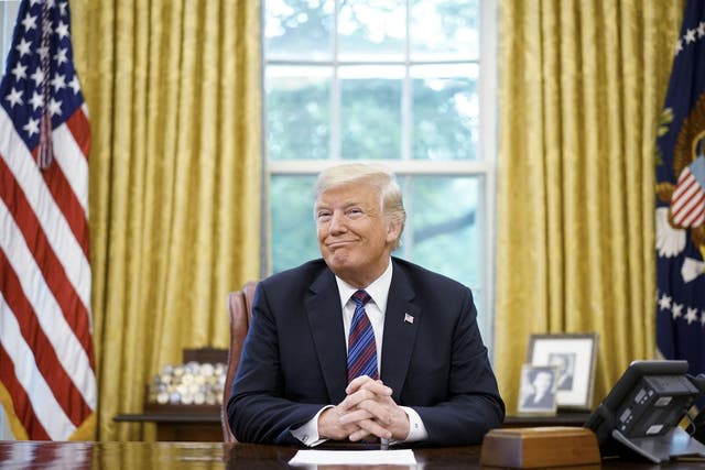 US President Donald Trump smiles during a phone conversation with Mexico's President Enrique Pena Nieto on trade in the Oval Office of the White House in Washington, DC on August 27, 2018