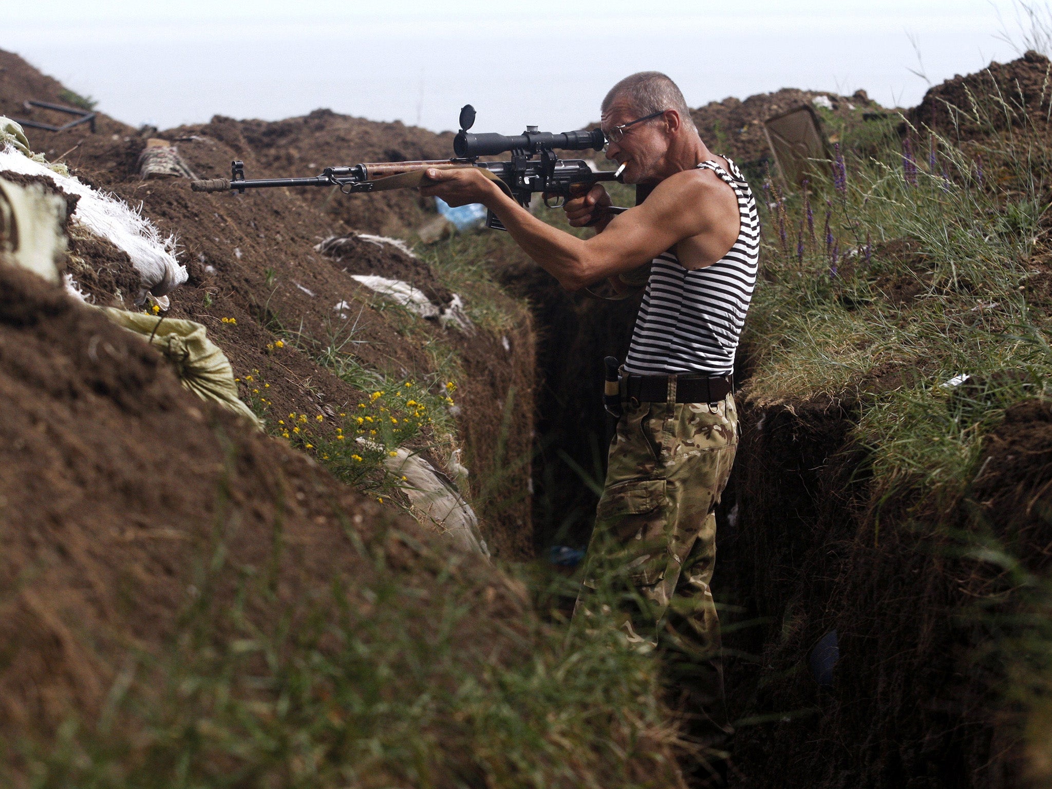 A marksman of the Donbass Battalion, a volunteer militia group devoted to ensuring a united Ukraine, looks down the scope of his rifle searching for pro-Russian separatists (AFP/Getty )