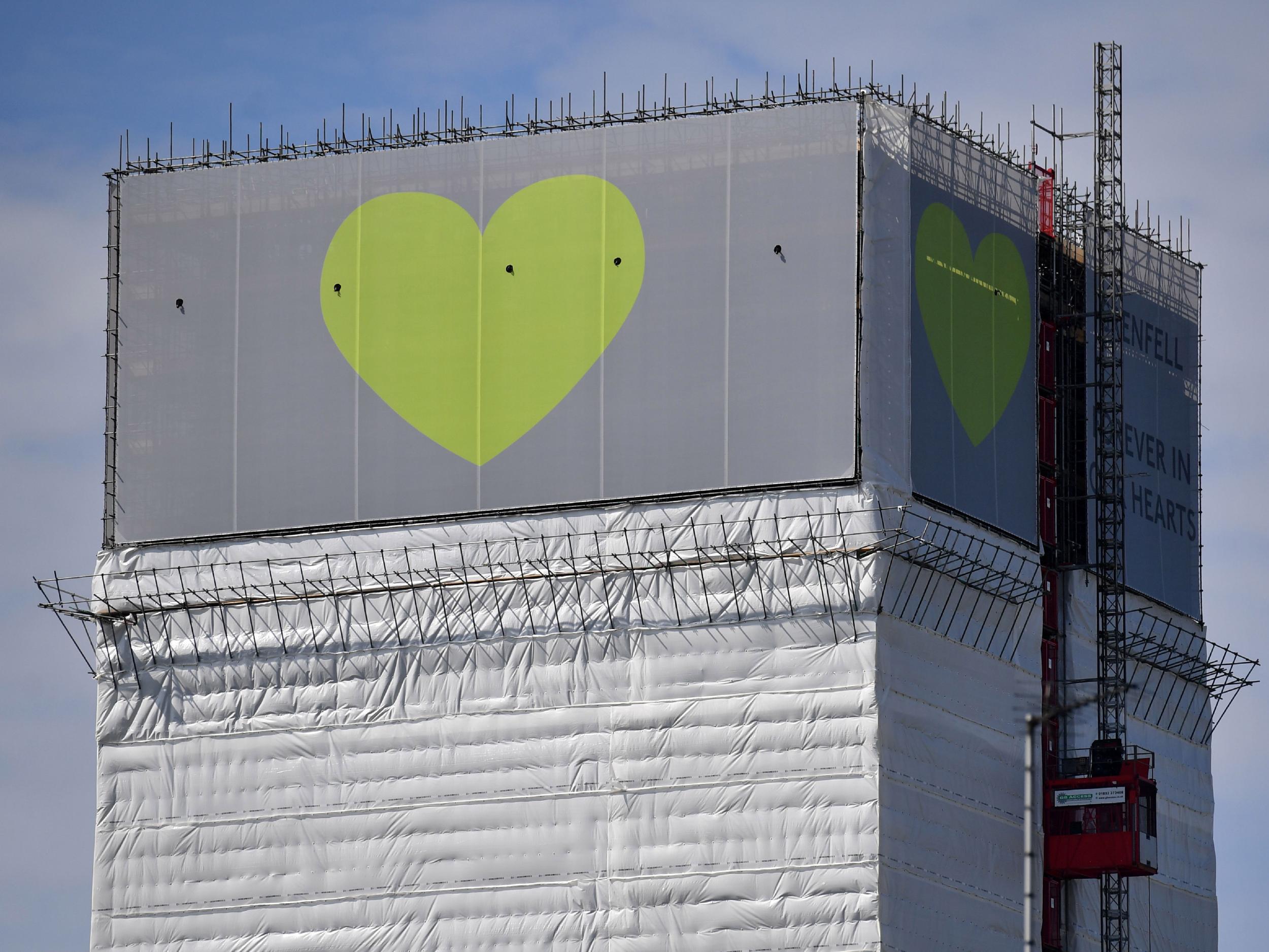 The structure is currently wrapped in white plastic sheeting, with a banner bearing a green heart hung from the top, but there are still fears the tower is causing distress