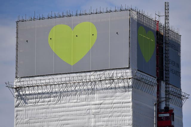 The structure is currently wrapped in white plastic sheeting, with a banner bearing a green heart hung from the top, but there are still fears the tower is causing distress