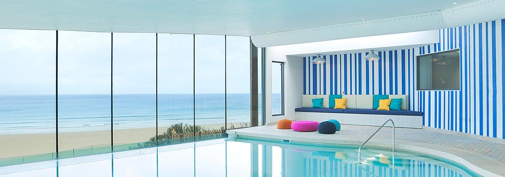 The glass-walled pool overlooking the sweeping beach at Watergate Bay